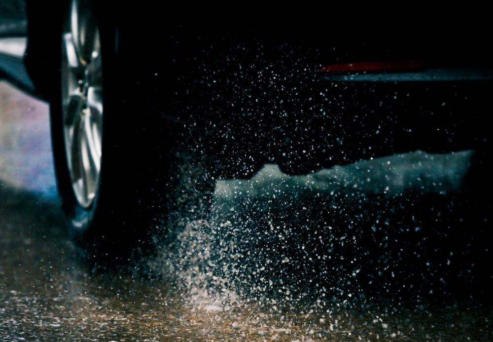 car splashes dirty water on road