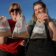 Researchers hold water sample bags from the river, canal, and floodplain, demonstrating the productivity of invertebrates in the floodplain.