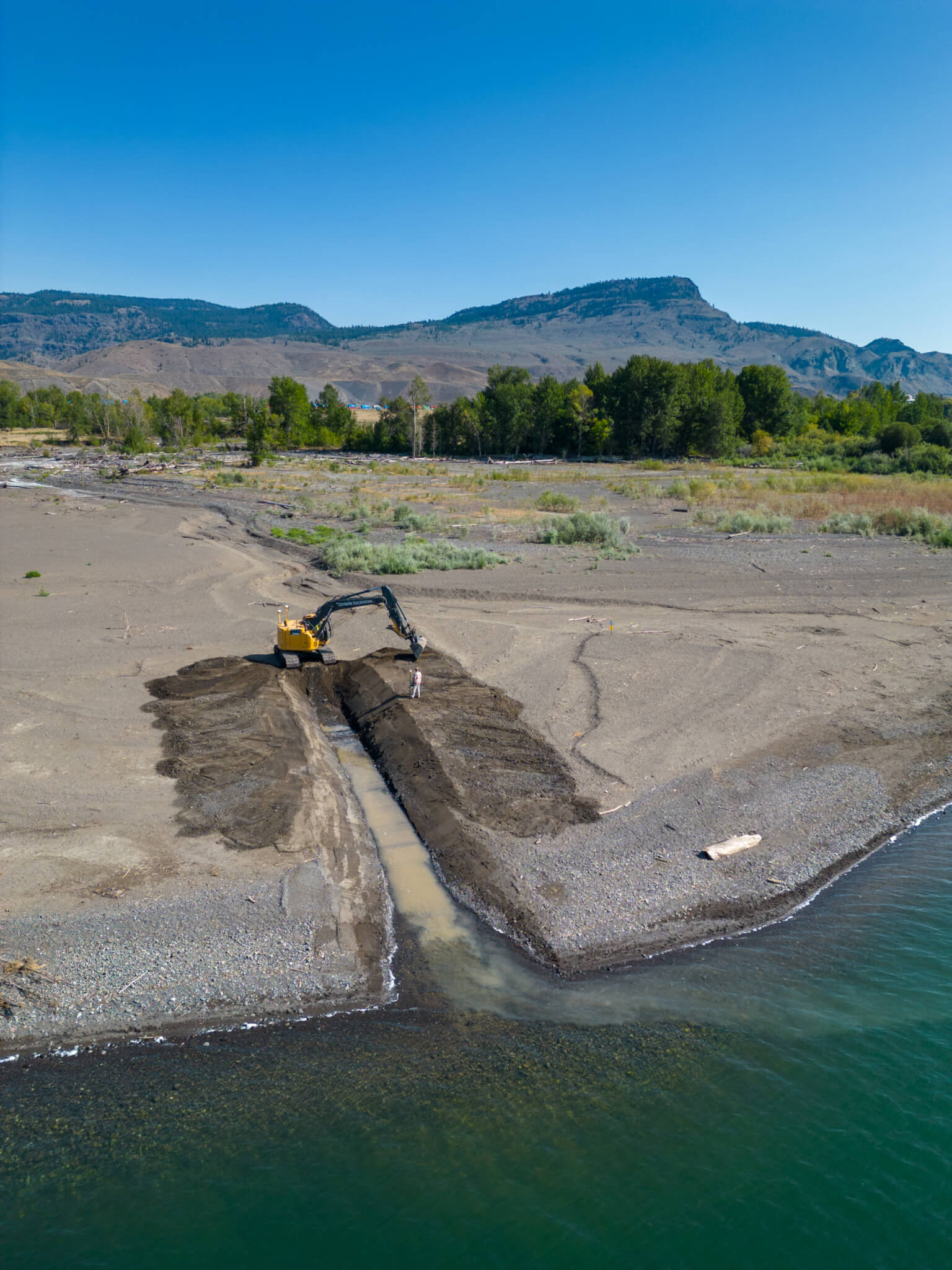 An excavator digs a channel to restore water flows.